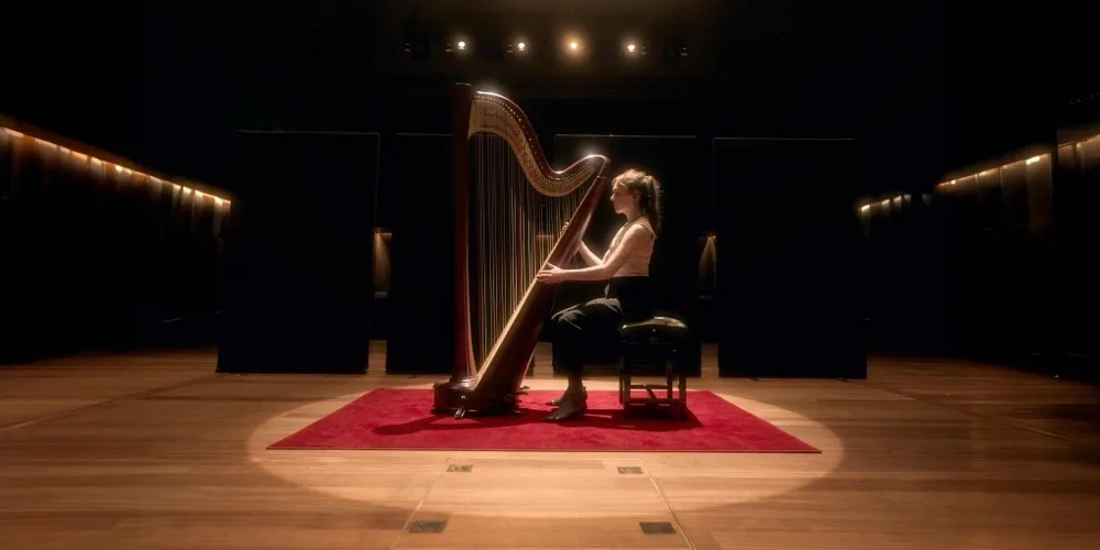 Yvonne alone with the harp on the empty concert hall stage