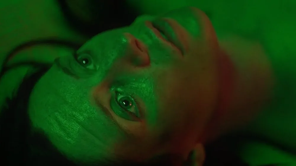 Green-lit close-up from the short film Black Sand