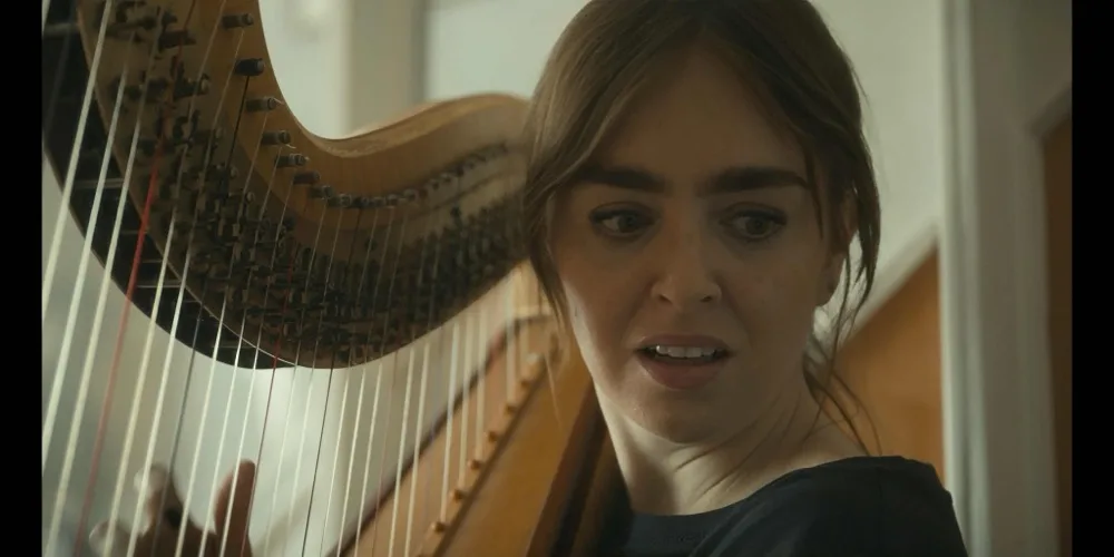 Maria plays the harp in the hallway of the family home